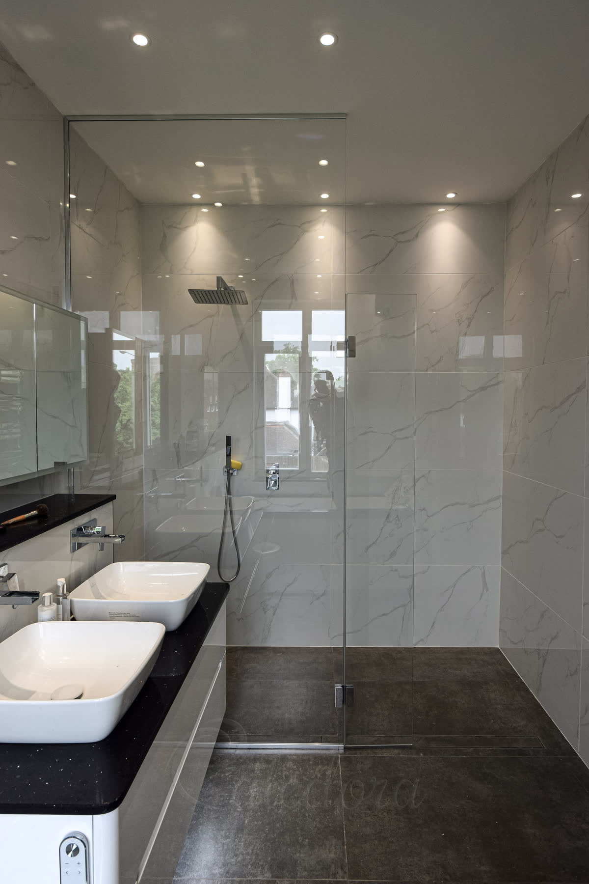 Large frameless shower screens for walk-in design with moveable flipper panel, easy clean glass, chrome fittings, marble walls in luxury bathroom