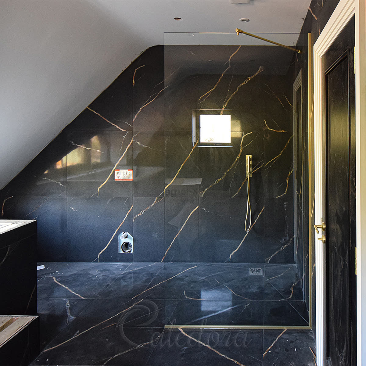 Frameless brushed gold shower screen seated in a wall-mounted U-channel profile in a Romford bathroom