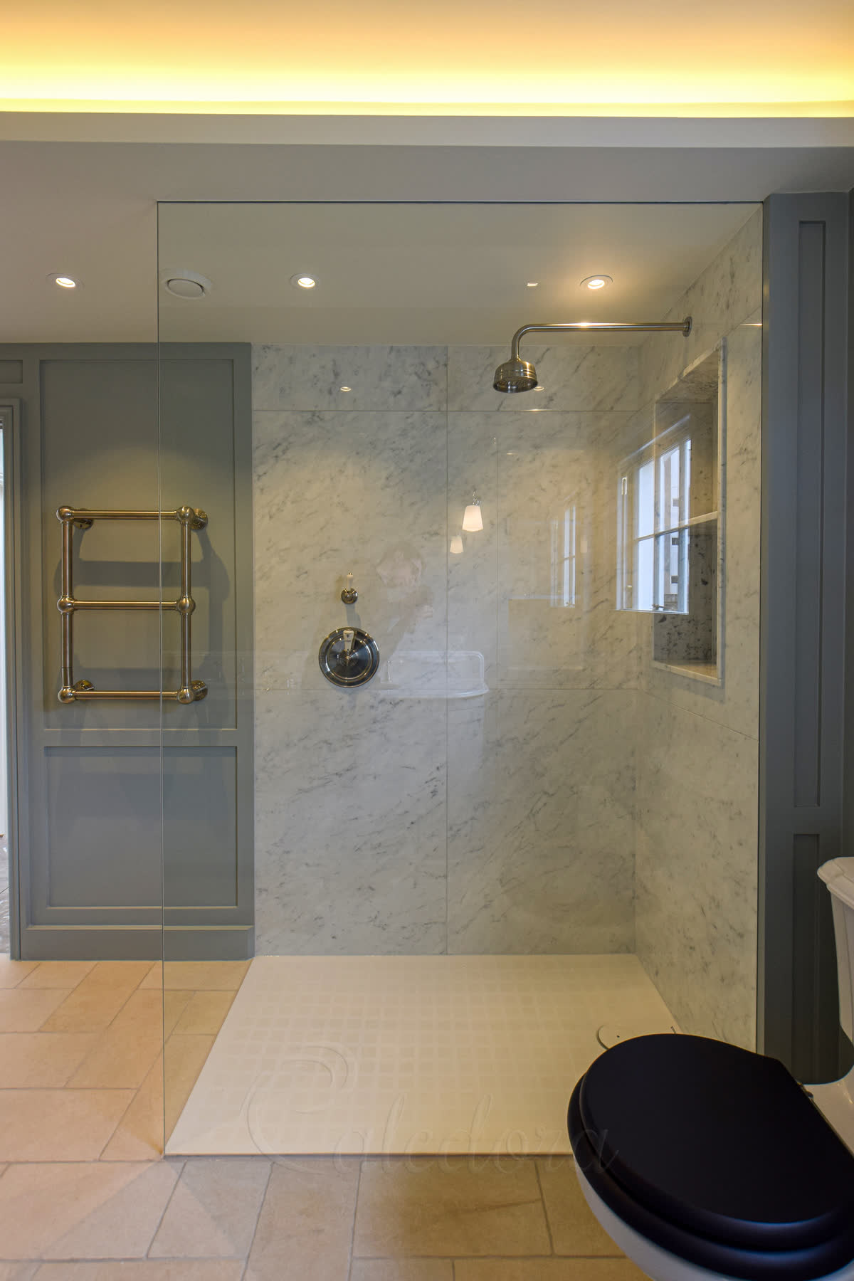 Floor-to-ceiling walk-in shower screen with open side and full-height single panel of clear toughened glass in a London bathroom